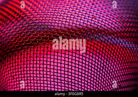Metal mesh grid glowing red and blue in diamond pattern abstract close up Stock Photo