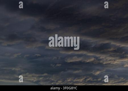 Sunlit stormy evening sky with dramatic banked clouds Stock Photo