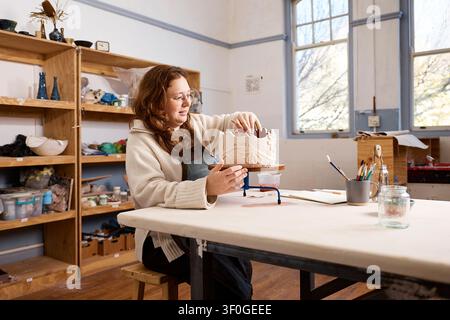 Female Pottery Artist in Her Studio Handcrafting Decorative Ceramic Bowl - Small Business Owner at Work Stock Photo