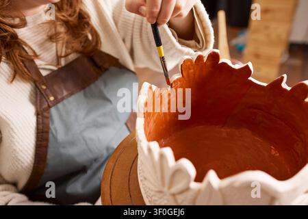 Female Pottery Artist Painting Glazed Ceramic Vase in Pottery Studio As Small Business Owner Stock Photo