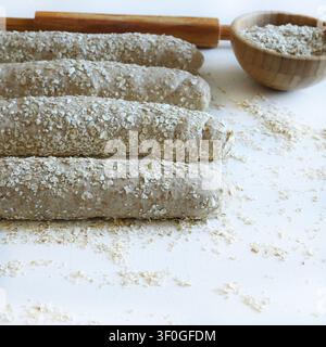 Homemade whole wheat oat bread on a floured surface with rolling pin.  Healthy baking and organic food. Traditional bakery and bread making. Stock Photo