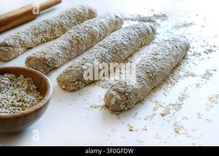 Homemade whole wheat oat bread on a floured surface with rolling pin.  Healthy baking and organic food. Traditional bakery and bread making. Stock Photo