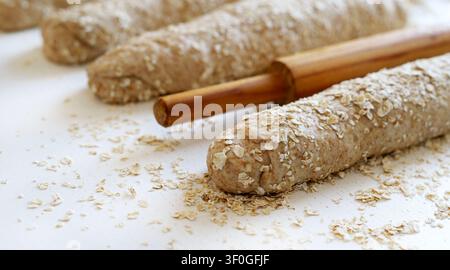 Homemade whole wheat oat bread on a floured surface with rolling pin.  Healthy baking and organic food. Traditional bakery and bread making. Stock Photo
