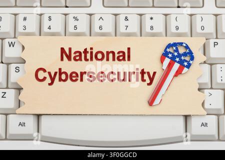 National Cybersecurity text on a wood sign with American flag key on a white computer keyboard for protection and encryption Stock Photo