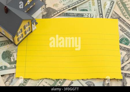 Blank lined paper with car keys on twenty dollar bills for mortgage, insurance and maintenance Stock Photo