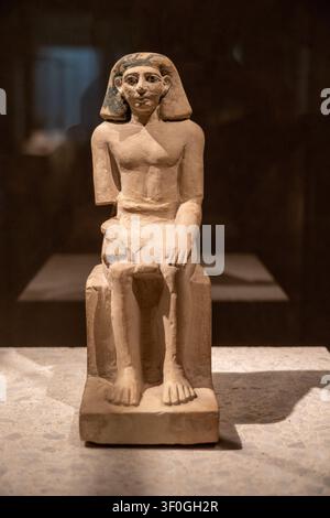 Berlin, Germany - 23 May 25: Museum photograph of a small seated ancient Egyptian figure displayed at the Neues Museum in Berlin, Germany. Stock Photo