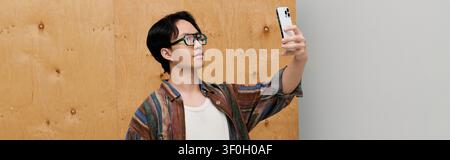 Young man with a handsome look takes a selfie while showcasing his elegant fashion sense. Stock Photo