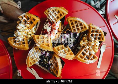 Gourmet dessert waffles with topping assortment on red table Stock Photo