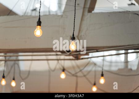 Hanging incandescent edison light bulbs in industrial interior Stock Photo