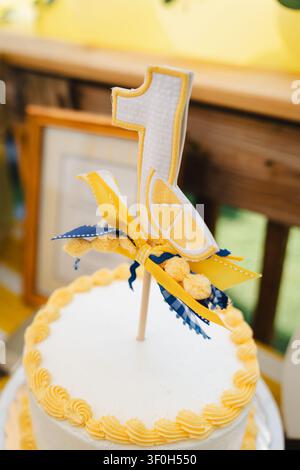 Lemon themed first birthday cake with yellow number one topper Stock Photo