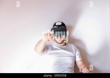 Man wearing a virtual reality headset and interacting with a digital interface Stock Photo