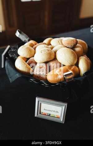 Assorted fresh bread rolls in a black fabric lined basket Stock Photo