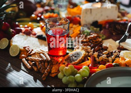 Abundant charcuterie board with red drink and assorted snacks Stock Photo