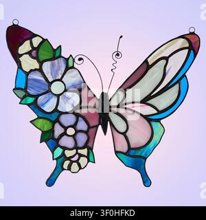 Stained glass butterfly suncatcher with blue and purple flowers on one wing. Handmade artwork placed on light violet gradient background. Stock Photo