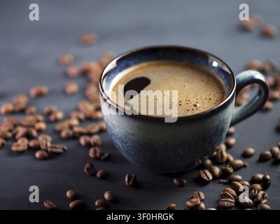 Blue Cup of fresh hot espresso coffee on a dark table with coffee beans Stock Photo