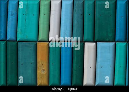 Abstract background of rectangular wooden panels with beveled edges, painted in vibrant shades of blue, teal, green, white, and yellow with a textured Stock Photo