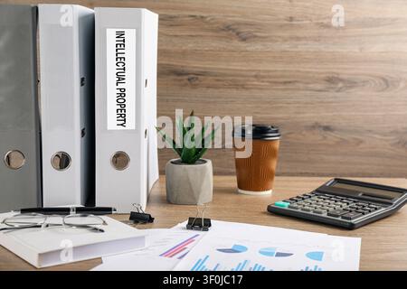 Intellectual property. Folders, documents and stationery on wooden table Stock Photo