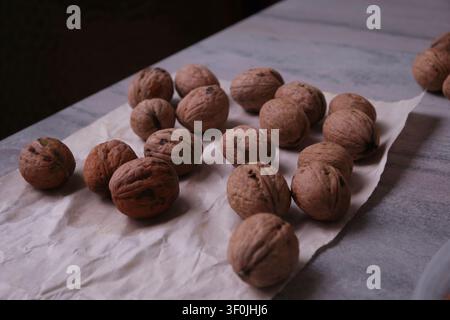 Close-up of whole walnuts with textured shells on a rustic wooden table Stock Photo