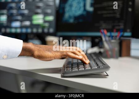Engineer typing on keyboard, doing maintenance on data center to improve it for AI workloads. Stock Photo