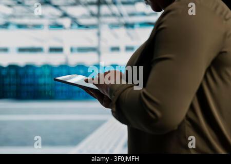 Data center administrator uses a tablet to install and configure equipment, supporting reliable infrastructure operations. Stock Photo