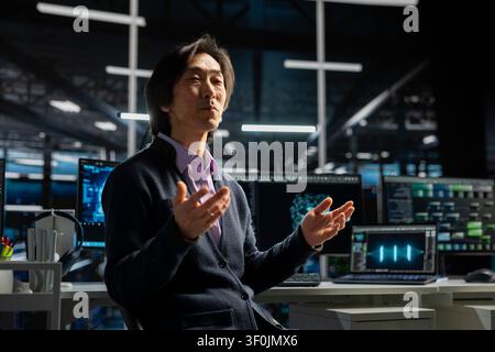 Computer scientist in server room working with device to review infrastructure diagnostics. Stock Photo