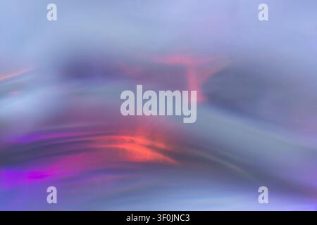 Soft abstract iridescent surface with blurred violet, blue, pink and orange light reflections creating a smooth futuristic background. Stock Photo