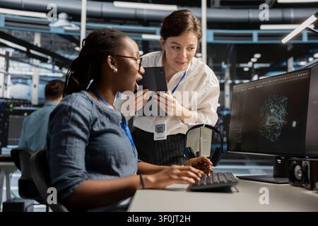 Data center team works together on diagnostics, maintenance tasks and server equipment performance checks. Stock Photo