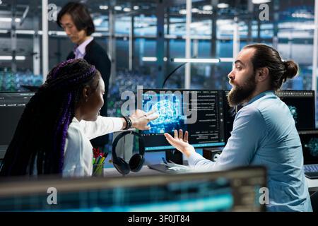 Programming team members resolve server connection problems in a server room with artificial intelligence support. Stock Photo