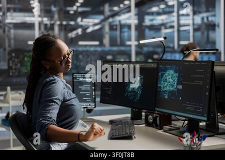 Technical specialist in server facility office working with AI powered tech to run simulations. Stock Photo