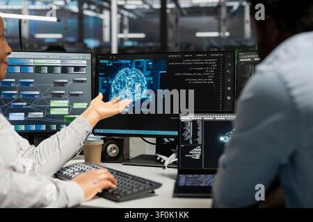 Engineering team inspecting neural network server room used for machine learning. Stock Photo