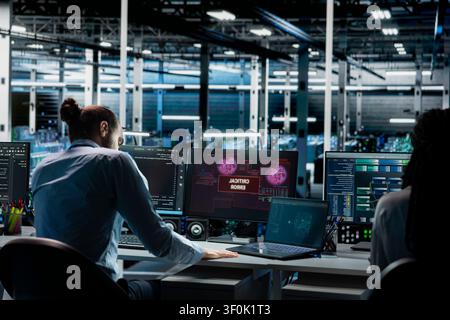 Teamworking server room admins try to fix system faults working with AI tools. Stock Photo