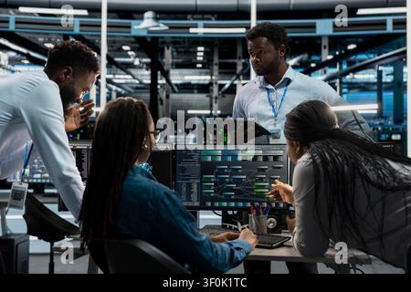 System administrators run code on a PC in an AI data center to upgrade artificial intelligence systems for machine learning training. Stock Photo
