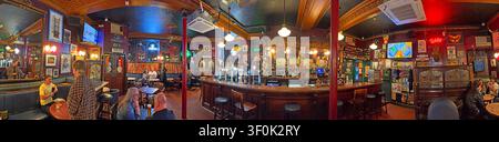 Panoramic interior of The Phoenix pub on Nethergate, Dundee, showing its traditional wooden bar, customers and historic characte Stock Photo
