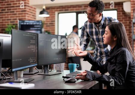 Multiethnic cyber security team developing software algorithm for information processing combines data protection, software systems and secure infrastructure in a technology workspace. Stock Photo