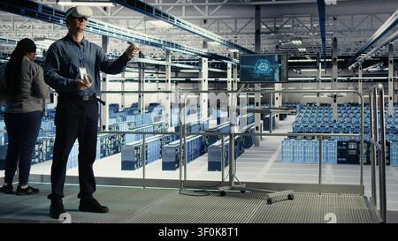 Programmer uses a VR headset in a server room to adjust AI systems and improve processing performance. Stock Photo