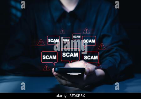 Online scam alert notification on smartphone screen. woman using mobile phone, cyber fraud warning pop up, internet security, phishing message detect Stock Photo