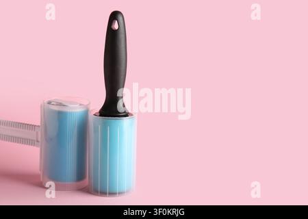 Different lint rollers on pink background Stock Photo