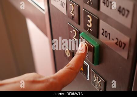 Pressing the elevator button in a bustling building Stock Photo