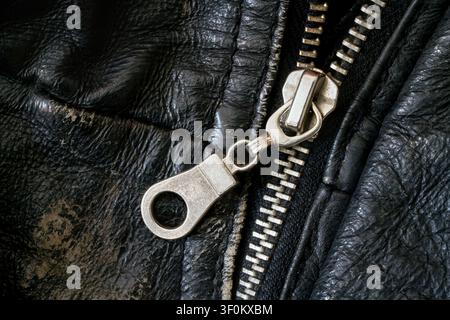 Zipper closure on shabby leather jacket. Metal clasp on the background of genuine leather. Stock Photo