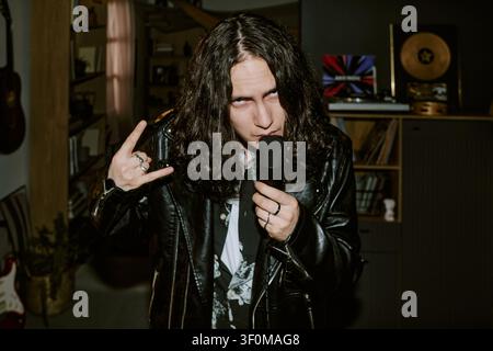 Portrait of Man Performing Rock Music at Home Studio Stock Photo
