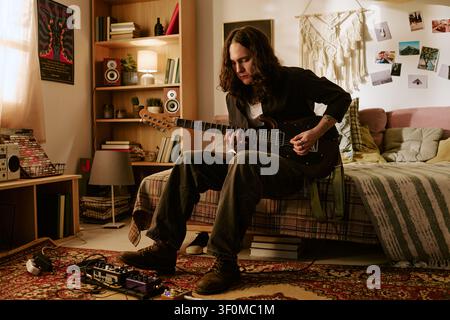 Young Man Playing Electric Guitar at Home for Music Practice Stock Photo