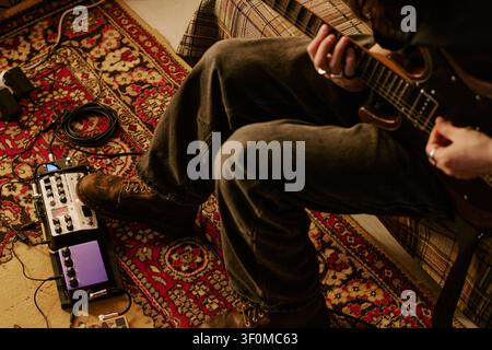 Man Playing Electric Guitar at Home for Music Production Stock Photo