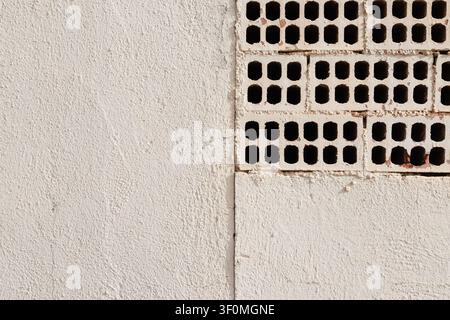 White Painted Wall with Exposed Perforated Bricks  Stock Photo