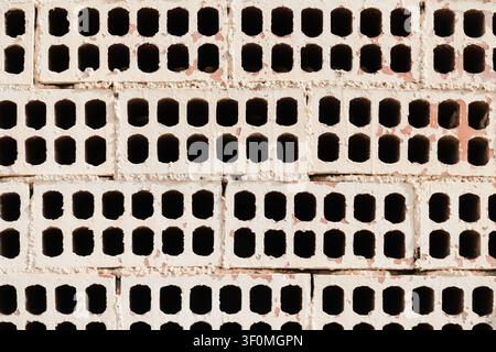 White Painted Wall made with Exposed Perforated Bricks Stock Photo