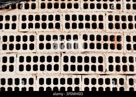 White Painted Wall made with Exposed Perforated Bricks Stock Photo