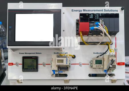 Industrial energy measurement solutions control panel featuring a programmable logic controller (PLC), power management meters, and a blank HMI touch Stock Photo