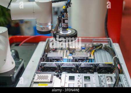 Close-up of an automated industrial robotic arm equipped with a high-resolution machine vision camera and LED ring light inspecting the internal compo Stock Photo