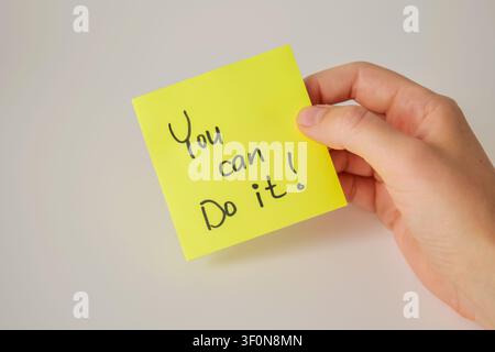 Hand Holding Yellow Sticky Note with You Can Do It Stock Photo