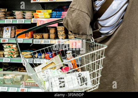 London UK, July 09 2026, Close Up Cropped Shot Of An Unrecognizable Woman Holding A Shopping Basket While Selecting Items From A Supermarket Shelf Stock Photo