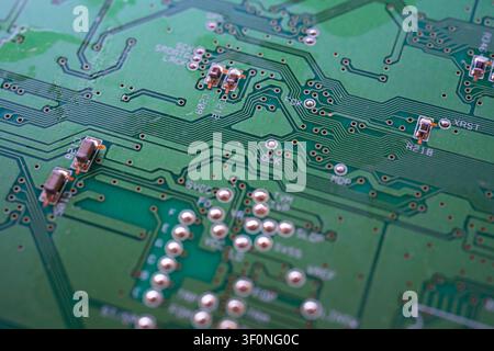 Macro photograph of a printed circuit board showing the conductive traces and small electronic components. Stock Photo